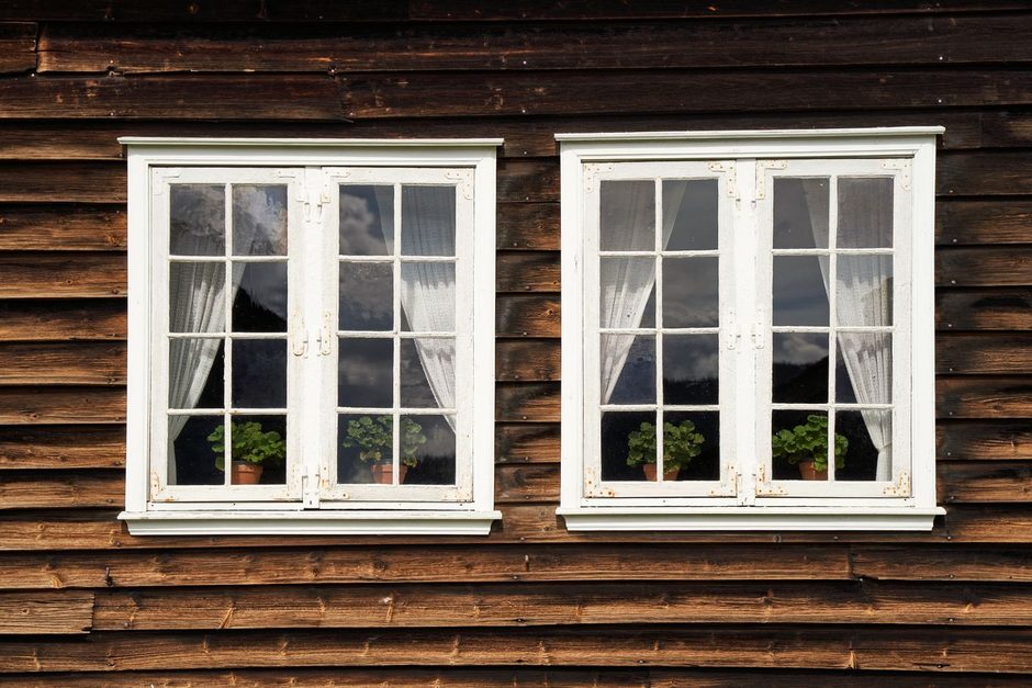 White framed double glazed windows set in a timber clad house facade. Photo by Barnabas Davoti on Pexels