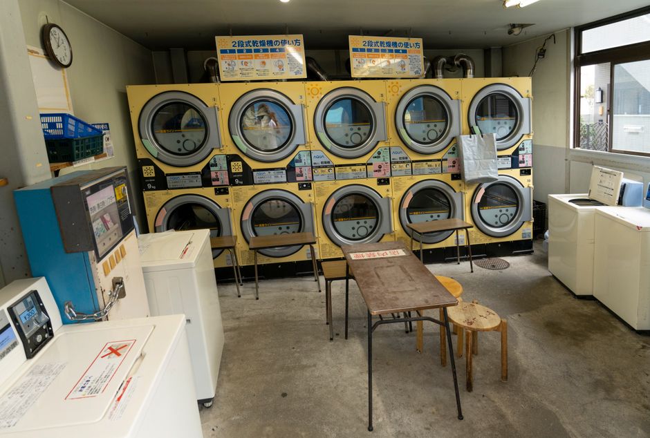 A compact laundromat in Tokyo with washing machines, dryers, and seating, showcasing urban lifestyle. Photo by Hugo Sykes on Pexels