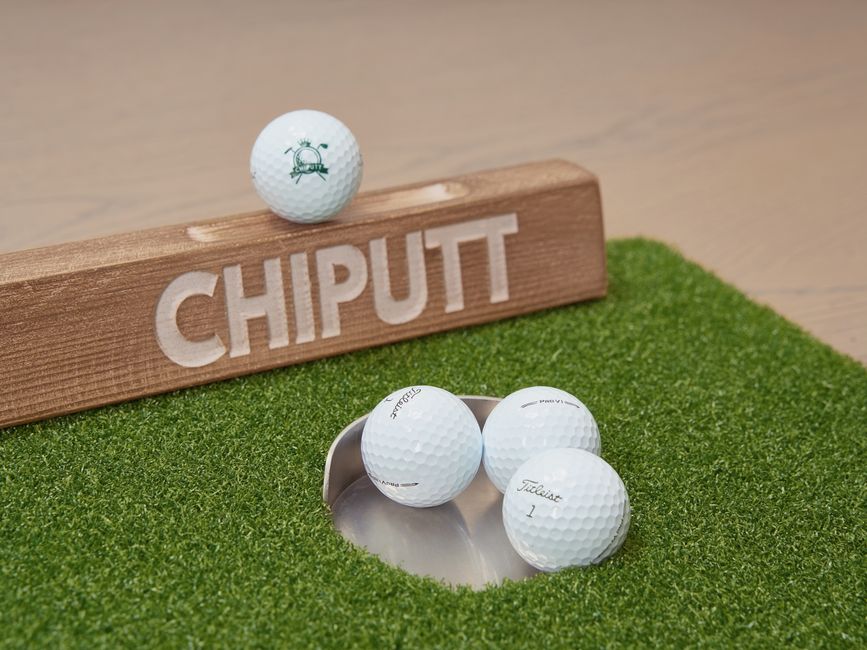 Wooden chipping putt board with golf balls on artificial green mat for training. Photo by Chiputt Golf on Pexels