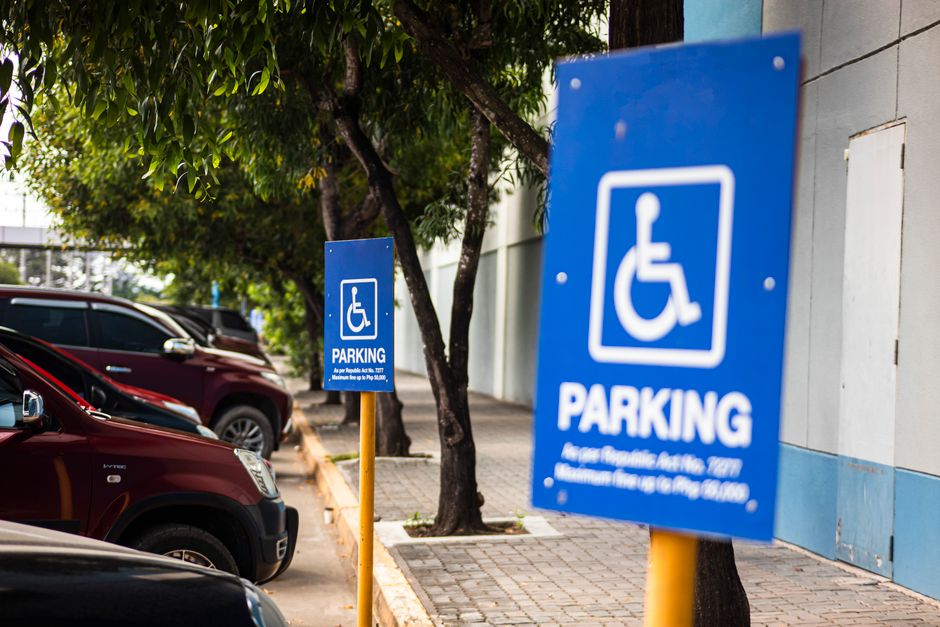 Photo by Nothing Ahead on Pexels Disabled sign hanging on post on parking lot with row of cars under tree branches. Photo by Nothing Ahead on Pexels