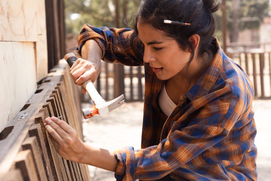 Photo by Los Muertos Crew on Pexels Woman in a plaid shirt repairing a wooden fence panel outdoors. Photo by Los Muertos Crew on Pexels