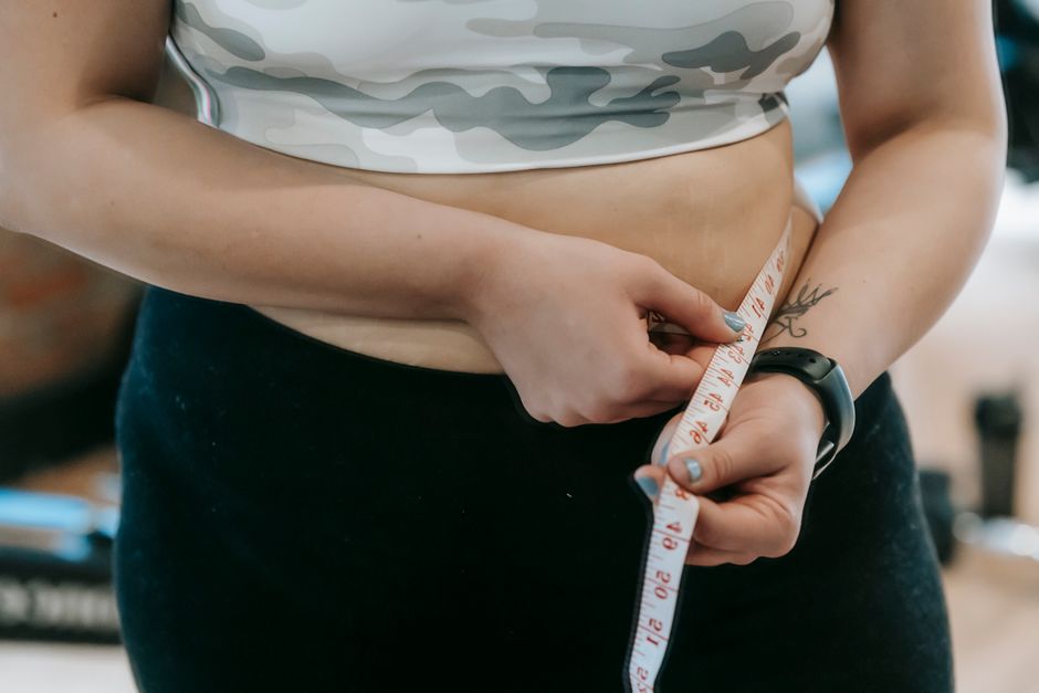 Photo by Andres Ayrton on Pexels Crop anonymous plus size female with measuring tape measuring waist on blurred background. Photo by Andres Ayrton on Pexels