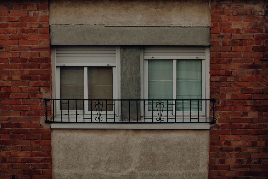 Photo by Juan Pablo Serrano on Pexels A rustic brick wall facade featuring double windows with metal railing, showcasing vintage architectural design. Photo by Juan Pablo Serrano on Pexels
