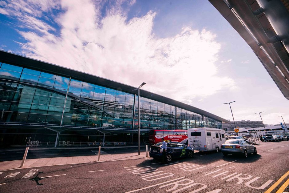 Line of taxis waiting at a taxi rank outside a modern terminal building. Photo by Ian Porce on Pexels
