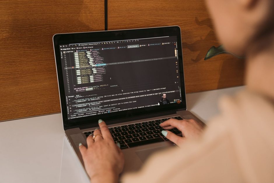 Photo by MART PRODUCTION on Pexels Person working at a laptop reviewing code on a wooden desk. Photo by MART PRODUCTION on Pexels