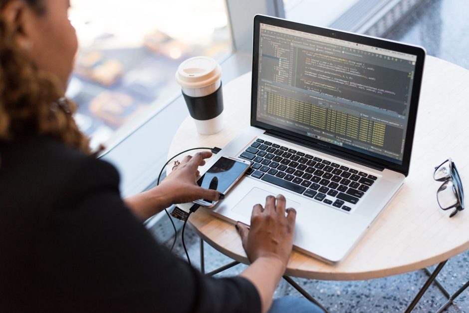 Web developer typing code on a laptop at a white table with a coffee. Photo by Christina Morillo on Pexels