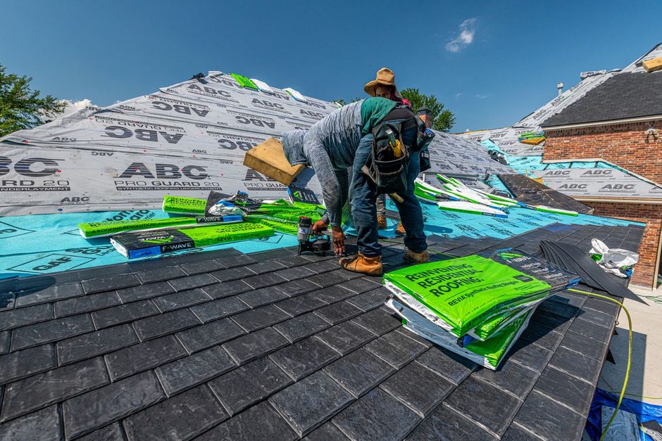 Roofers laying waterproof membrane on a pitched roof during a repair job. Photo by Ryan  Stephens on Pexels