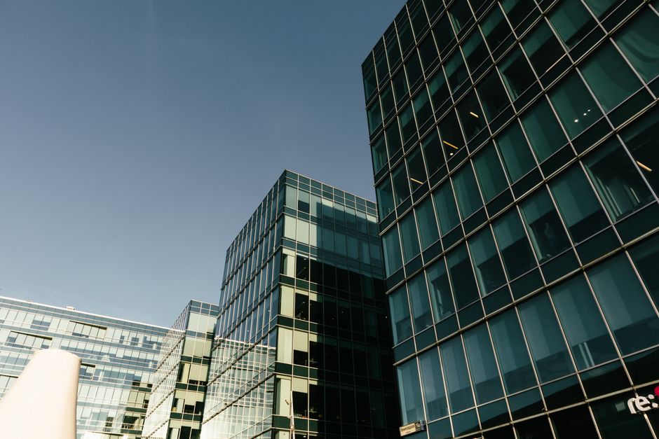 Elegant modern glass office buildings with reflective windows under a clear blue sky, showcasing urban architecture. Photo by Plato Terentev on Pexels