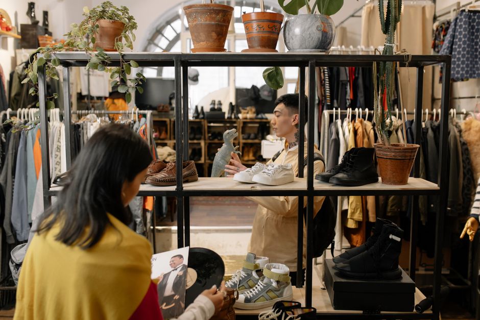 People browsing and selecting items in a stylish vintage clothing shop interior. Photo by cottonbro studio on Pexels