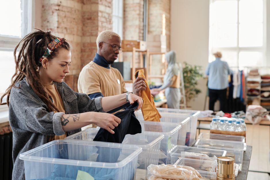 Volunteers organize donated clothing at a donation center, fostering community support and sustainability. Photo by Julia M Cameron on Pexels