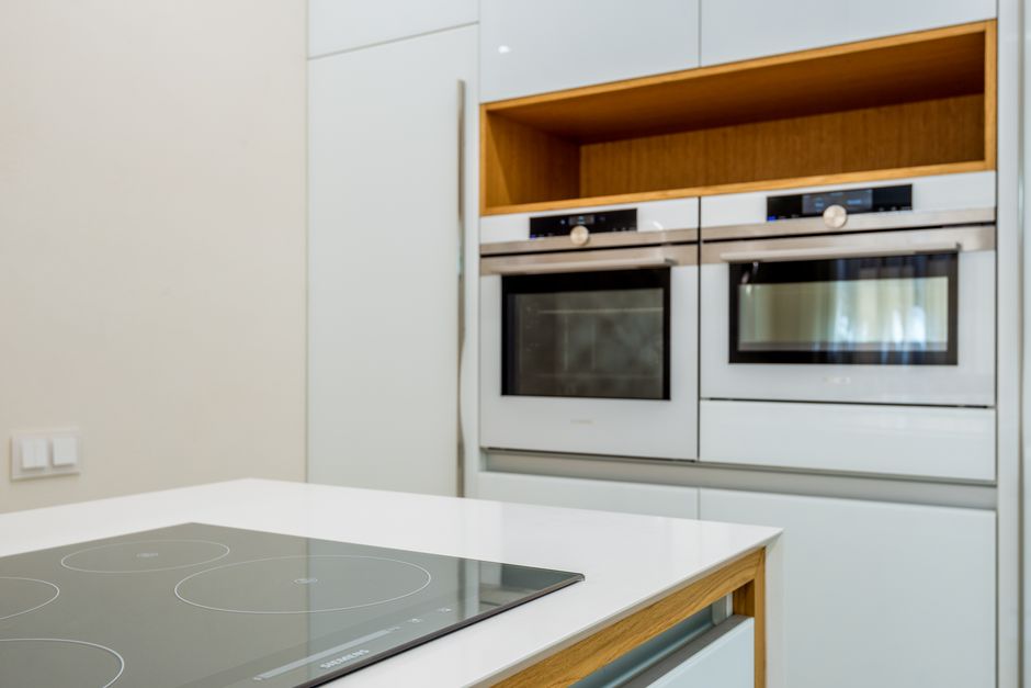 Interior of contemporary light kitchen with white ovens and clean new stove in modern apartment. Photo by Max Vakhtbovych on Pexels