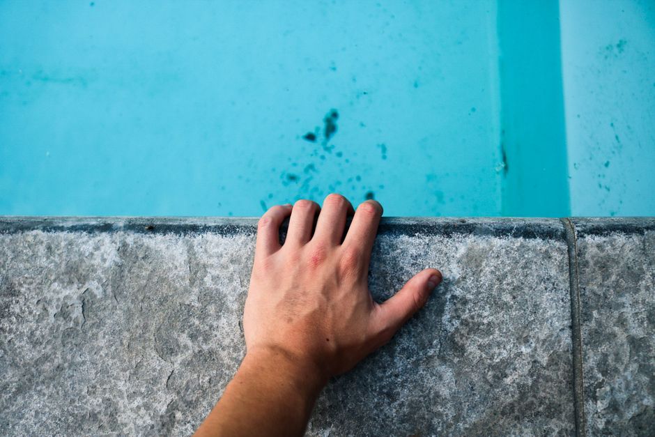 Photo by Sebastiaan Stam on Pexels Close-up of a human hand on a concrete edge by a pool with clear blue water. Photo by Sebastiaan Stam on Pexels