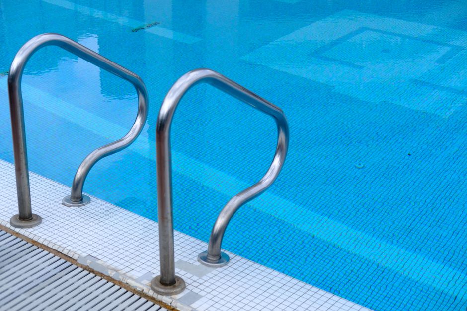 Photo by Towfiqu barbhuiya on Pexels Stainless steel pool ladder leading into a clear blue tiled swimming pool. Photo by Towfiqu barbhuiya on Pexels