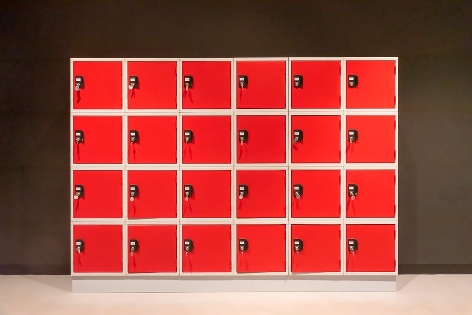 Simple indoor setup of vibrant red lockers with combination locks in a row. Photo by Jan van der Wolf on Pexels