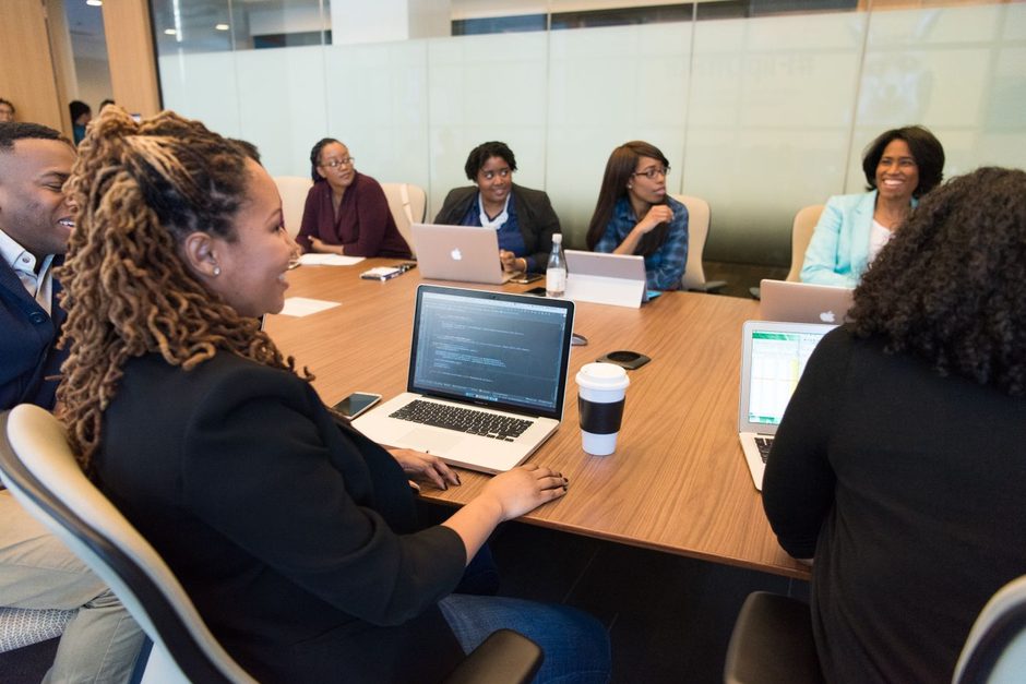 Business team seated around a conference table with laptops during a meeting. Photo by Christina Morillo on Pexels