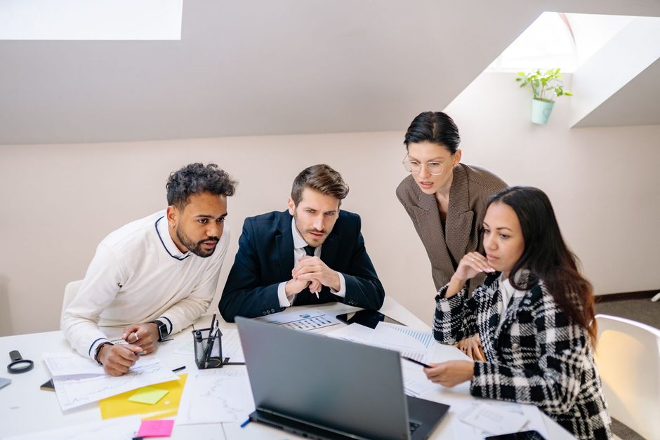 Photo by Yan Krukau on Pexels Colleagues collaborating around a desk with laptops and notes in a bright office. Photo by Yan Krukau on Pexels