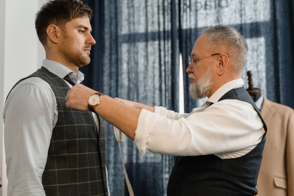 Professional tailor measuring a client for a custom suit in a workshop setting. Photo by Tima Miroshnichenko on Pexels