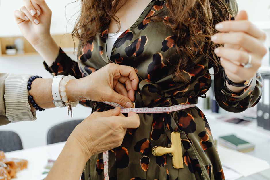 Photo by https://kaboompics.com/ on Pexels Close-up of a fashion designer measuring a dress with tape for precise fitting. Photo by https://kaboompics.com/ on Pexels