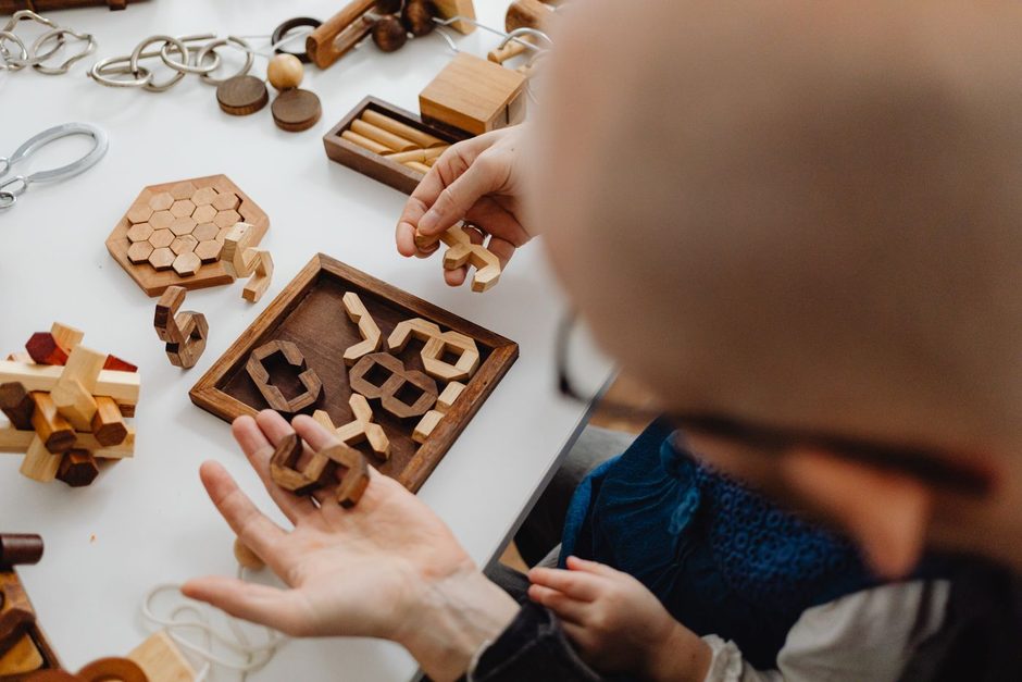 Photo by https://kaboompics.com/ on Pexels Hands solving a wooden puzzle together on a table. Photo by https://kaboompics.com/ on Pexels