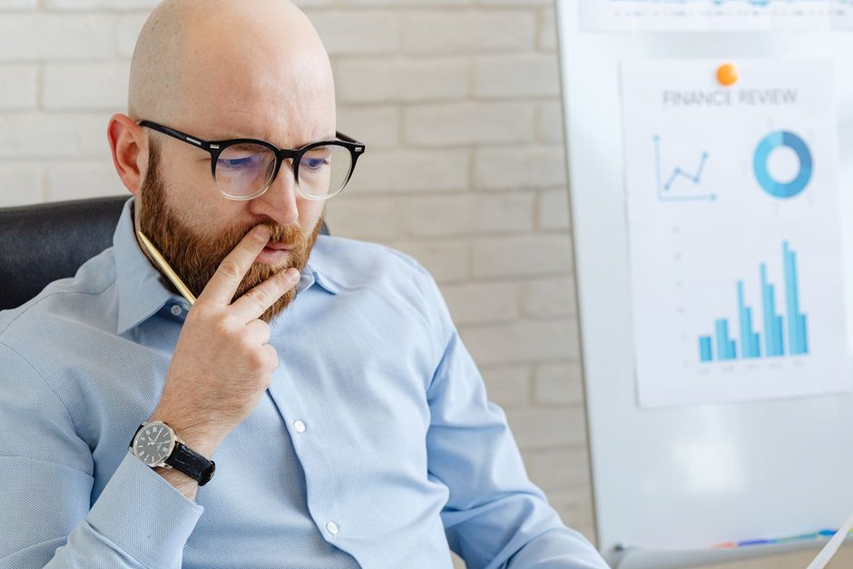 Man in glasses thinking beside charts while reviewing conversion data. Photo by https://kaboompics.com/ on Pexels