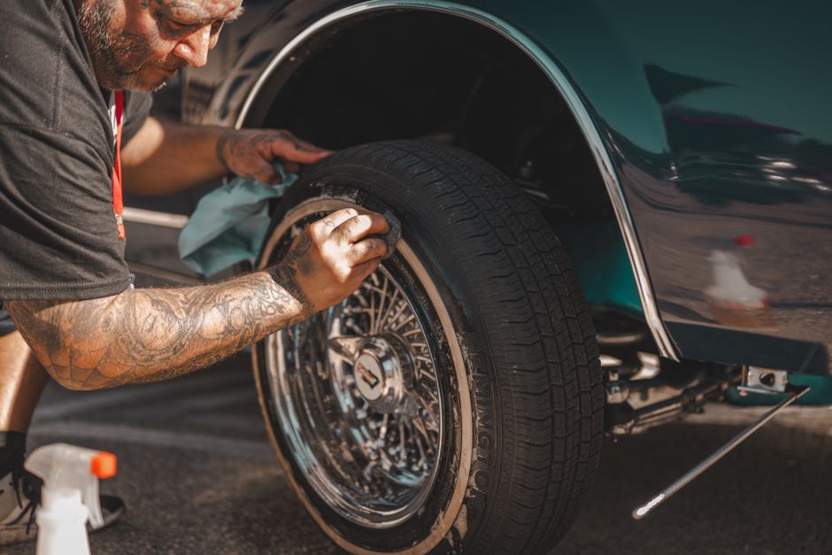 Photo by Mike Kutz on Pexels A man with tattoos polishes a classic car wheel, focusing on tire cleaning. Photo by Mike Kutz on Pexels