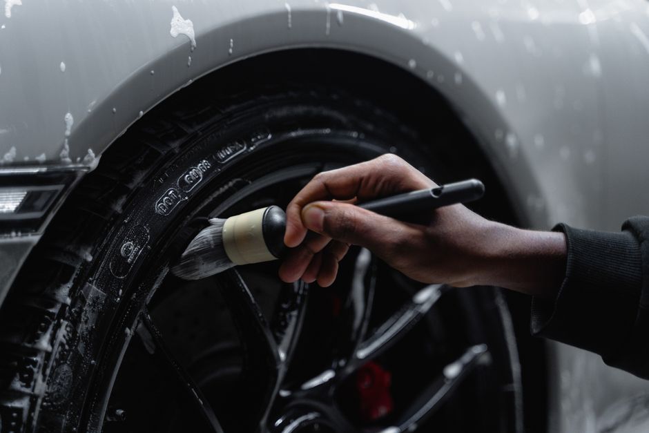 Photo by Tima Miroshnichenko on Pexels Detailed shot of a hand using a brush to clean a car tire and wheel during a wash. Photo by Tima Miroshnichenko on Pexels