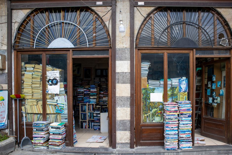 Vintage bookshop entrance with stacked books in Gaziantep, offering a cozy and nostalgic atmosphere. Photo by Zülfü Demir📸 on Pexels