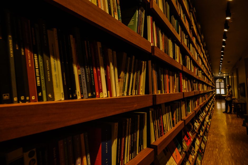 Photo by Ayşe İpek on Pexels Long shelves filled with books in a warmly lit library interior, ideal for reading enthusiasts. Photo by Ayşe İpek on Pexels