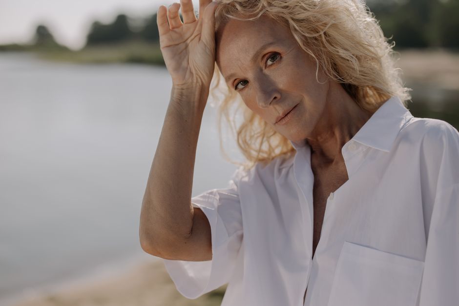 Portrait of a senior woman with blonde hair posing outdoors in sunlight. Photo by cottonbro studio on Pexels