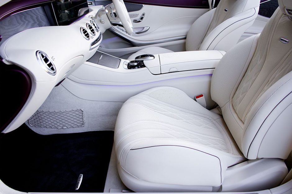 Detailer cleaning the white leather interior of a luxury car. Photo by Mike Bird on Pexels