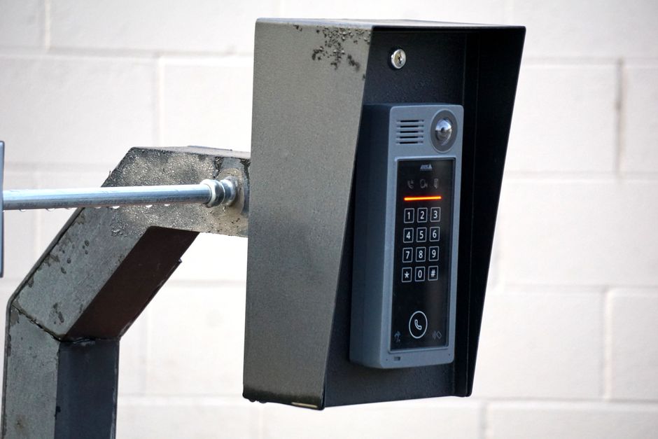 Close-up of a modern security intercom and keypad mounted on a wall outdoors with visible wiring. Photo by Joshua Brown on Pexels