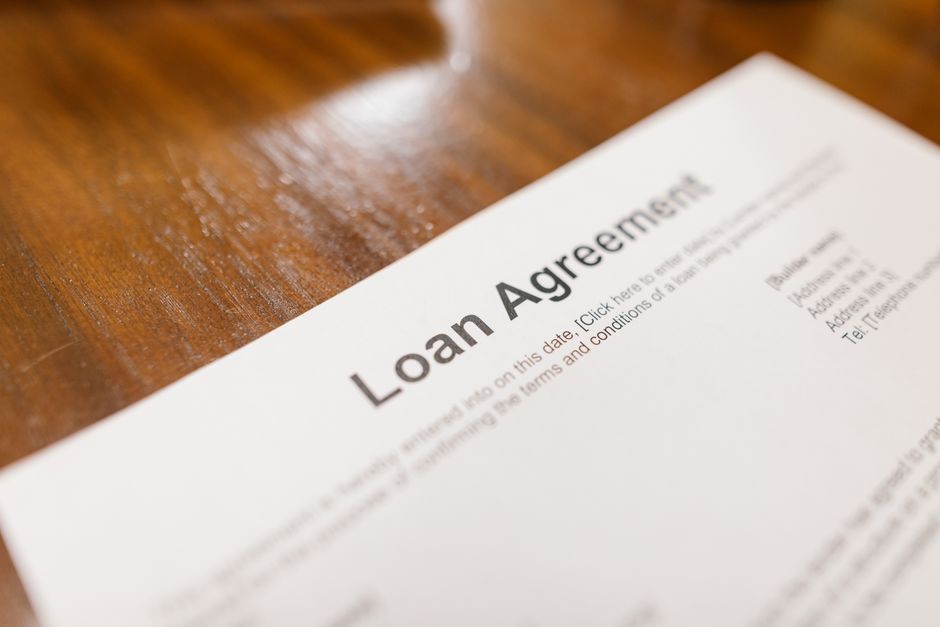 Detailed loan agreement document close-up on a wooden table representing legal and financial concepts. Photo by RDNE Stock project on Pexels