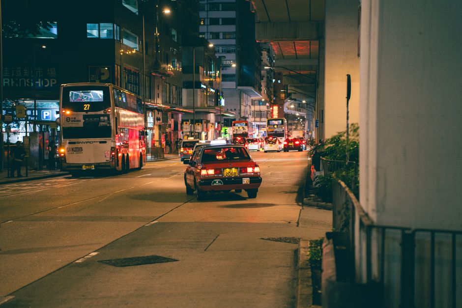 Vibrant city scene with buses and cars on a busy street in Hong Kong at night. Photo by lange x on Pexels