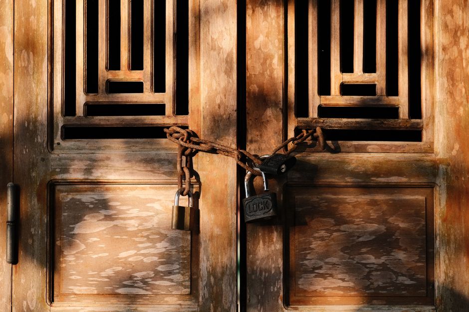 Photo by Pew Nguyen on Pexels A wooden door with intricate design securely chained with padlocks. Photo by Pew Nguyen on Pexels