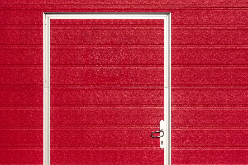 Photo by Jan van der Wolf on Pexels Minimalist image of a bold red garage door with a white frame and textured surface. Photo by Jan van der Wolf on Pexels