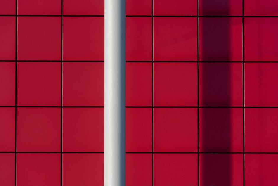 Photo by Jan van der Wolf on Pexels Abstract image of a red tiled wall with shadow and pole for modern creative design. Photo by Jan van der Wolf on Pexels
