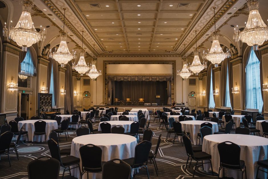Elegant event venue ballroom with round banquet tables set under chandeliers. Photo by Clément Proust on Pexels