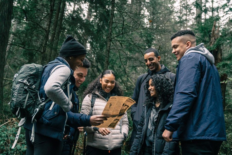 Group of adults with backpacks gathered on a forest trail during an outdoor activity. Photo by PNW Production on Pexels