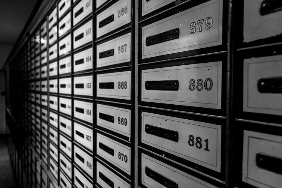 Wall of numbered bank safe deposit boxes in a secure vault room. Photo by Arif Kemal Köroğlu on Pexels