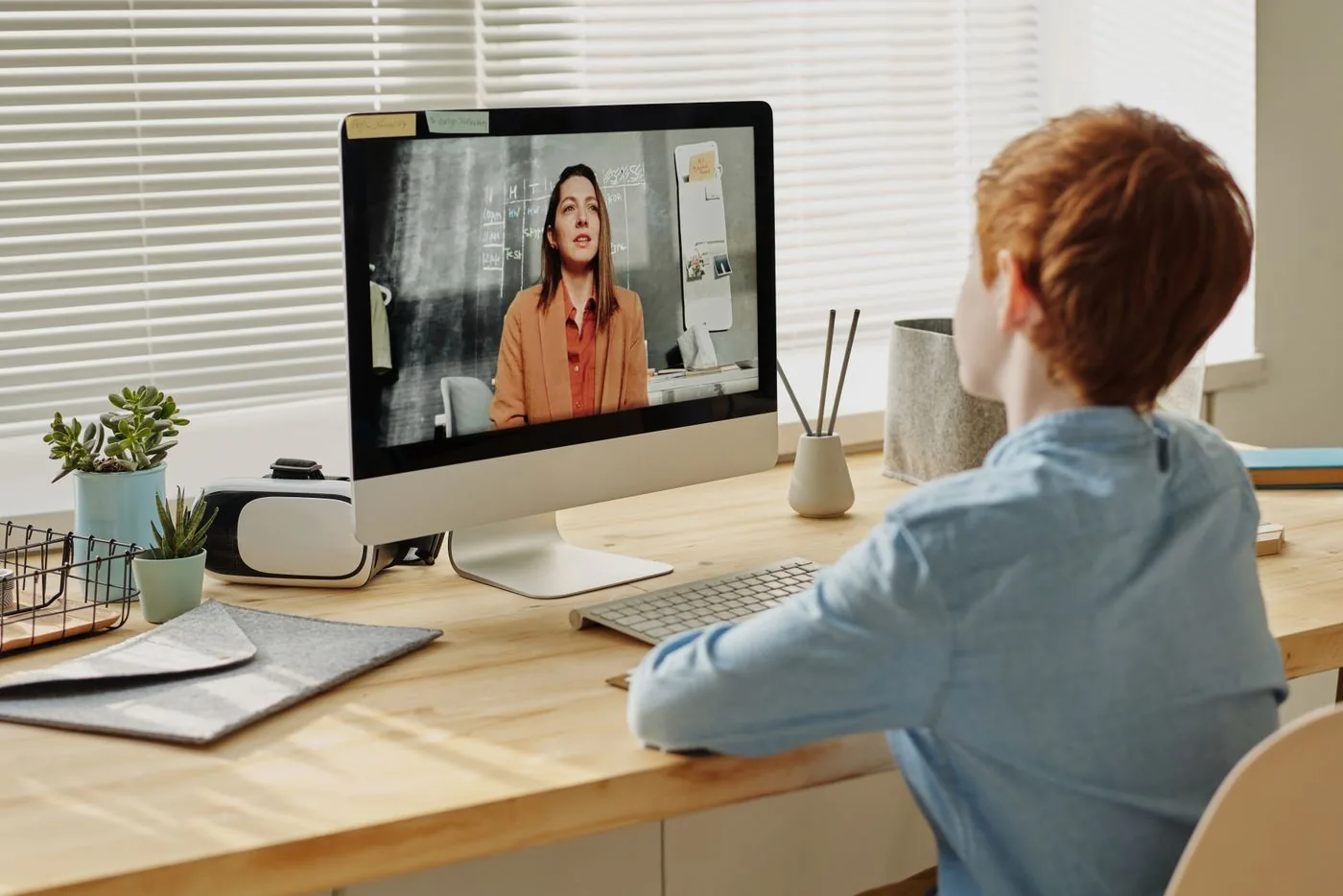 Student watching a live online class on a desktop computer. Photo by Julia M Cameron on Pexels