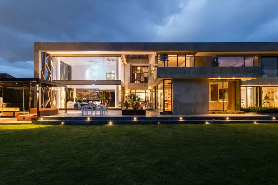 Modern architectural home with large windows at dusk. Photo by Gustavo Galeano Maz on Pexels