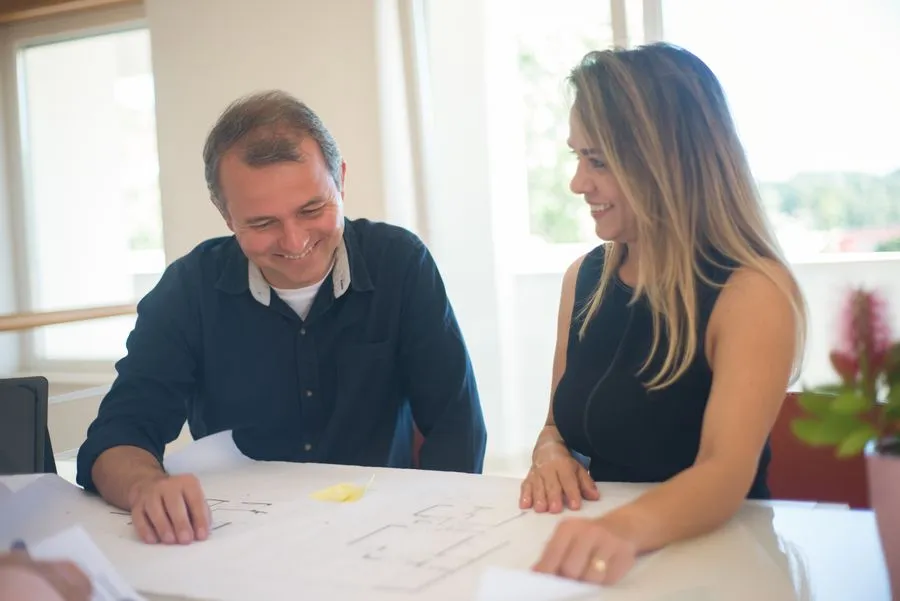Couple reviewing documents with a real estate agent at a table. Photo by Kampus Production on Pexels