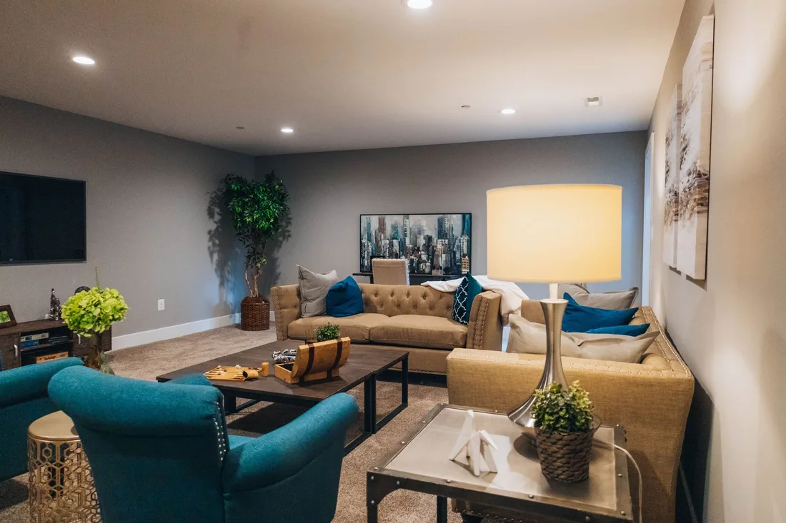 Warm, welcoming residents lounge with sofas, armchairs and soft lighting in the UK. Photo by Samuel Peter on Pexels