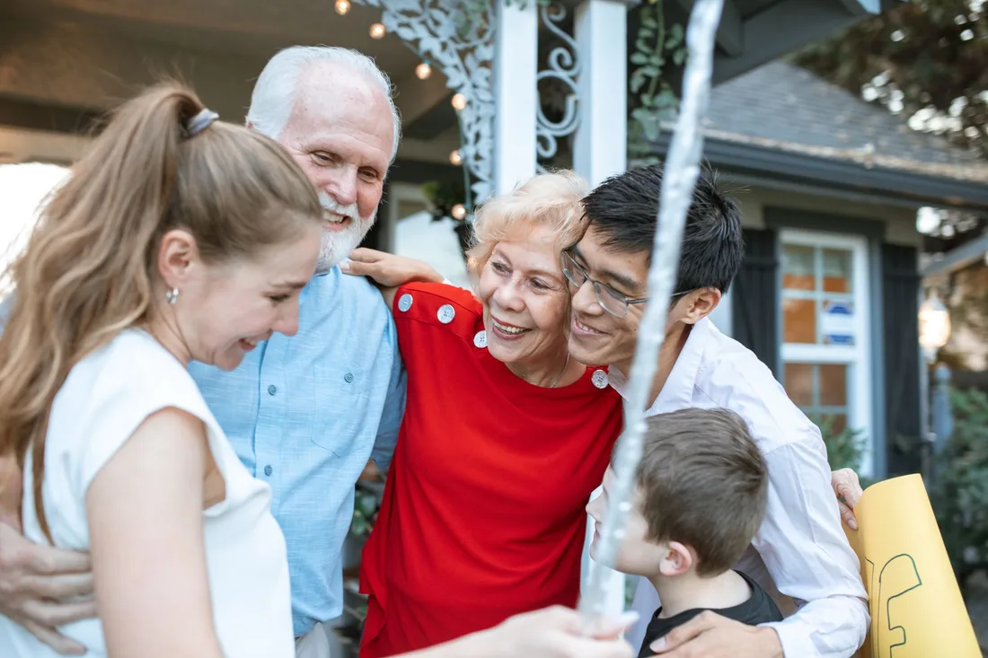 Grandparents laughing with their adult family members outside a home in Singapore. Photo by RDNE Stock project on Pexels