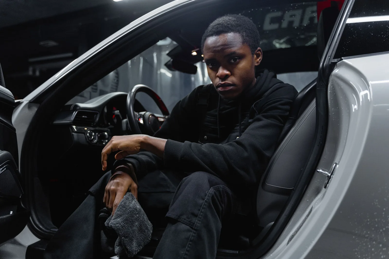 Young man cleaning car interior with cloth, emphasizing car care and maintenance. Photo by Tima Miroshnichenko on Pexels