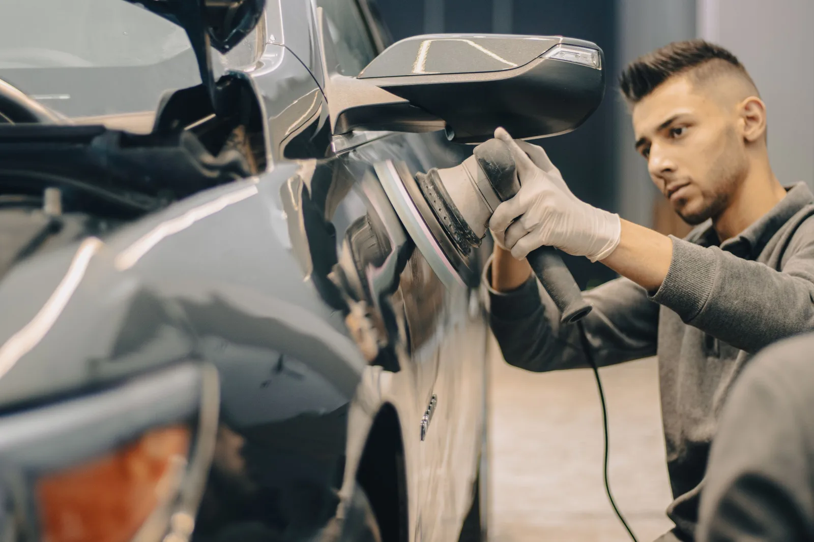 Technician sanding a car panel in a body shop. Photo by Dextar Studio ™ on Pexels