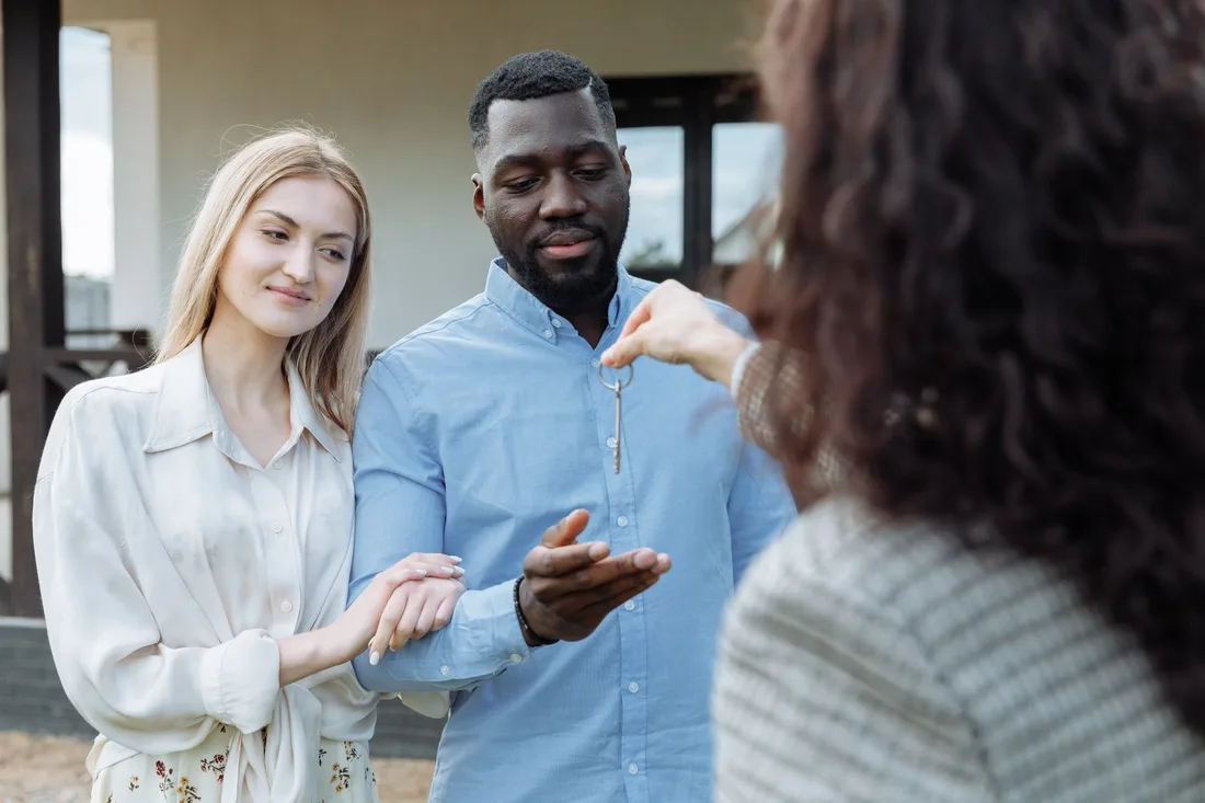 Smiling couple receiving car keys from a dealership salesperson. Photo by Thirdman on Pexels