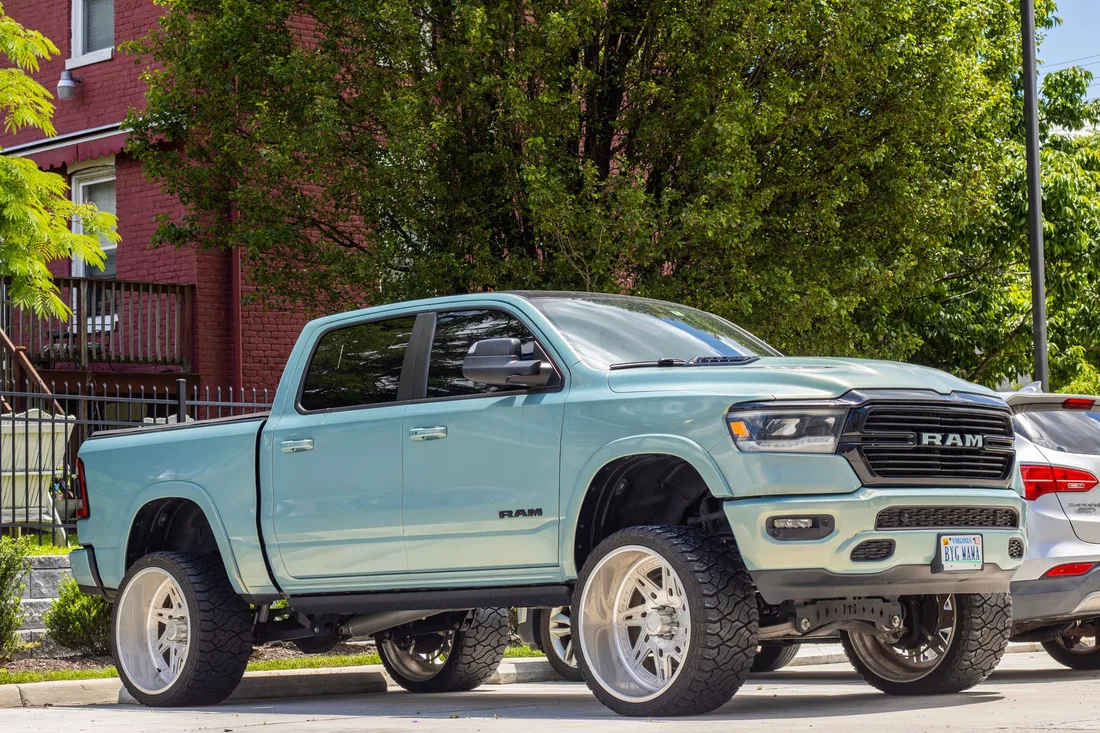 Customized RAM truck with large tires parked in a city neighborhood, showcasing urban style and automotive design. Photo by Zion Smith on Pexels