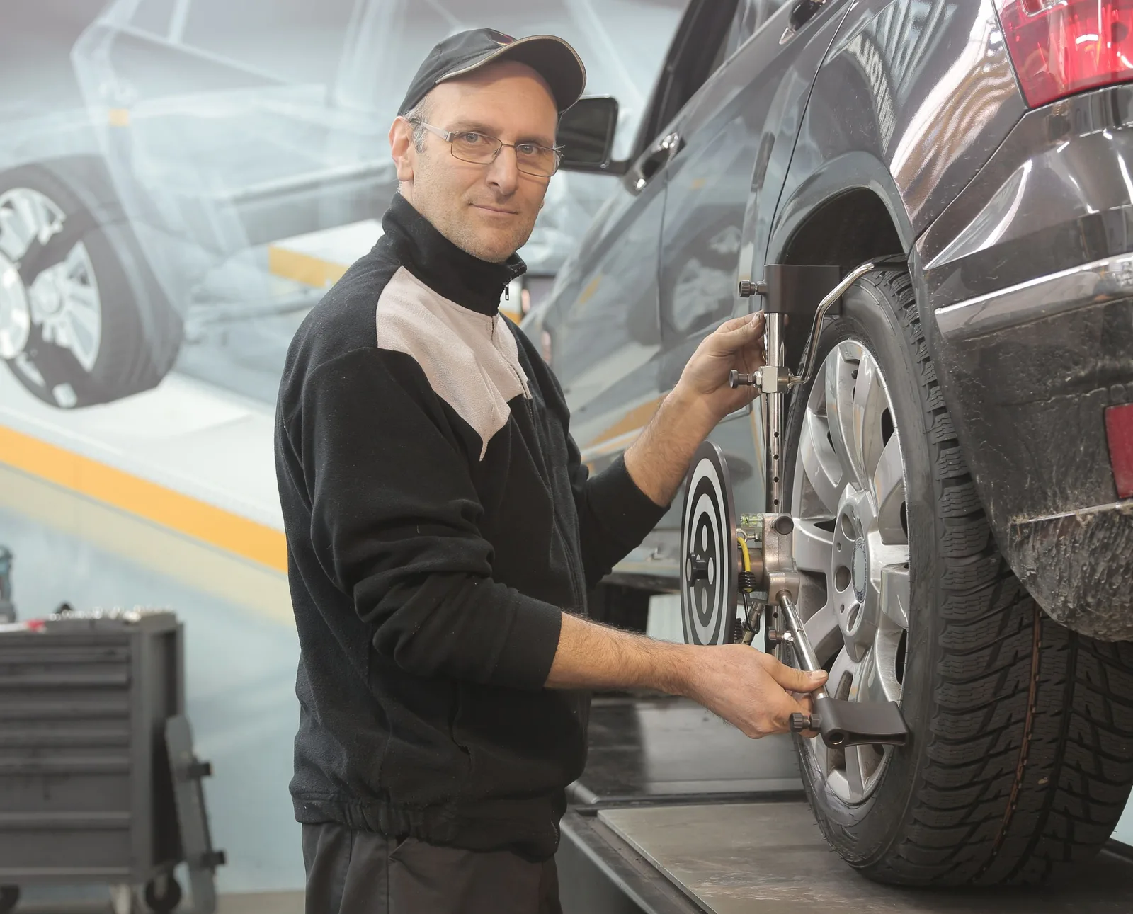 Mechanic performing wheel alignment on a car in a professional garage setting. Photo by Andrea Piacquadio on Pexels