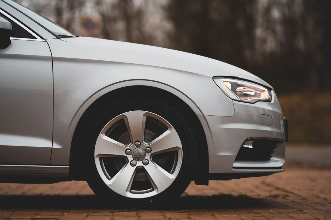 Silver car with clean alloy wheel and fitted tire parked on pavement. Photo by Omar Ramadan on Pexels